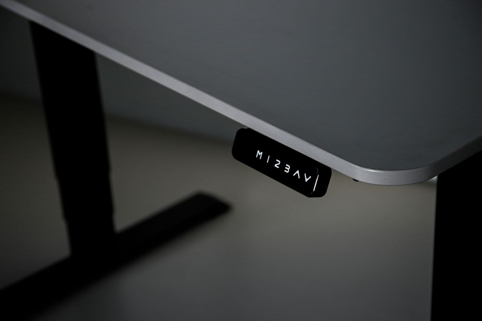 Touchscreen keypad glowing under the desk edge — real photograph
